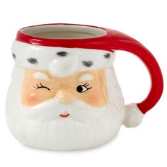 a ceramic santa claus mug with a red handle