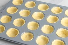 a muffin pan filled with cupcake batters on top of a white counter