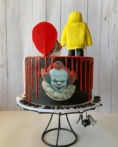 there is a cake that has been decorated with a clown and balloon on top of it