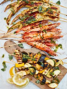 grilled shrimp and vegetables on skewers with lemon wedges