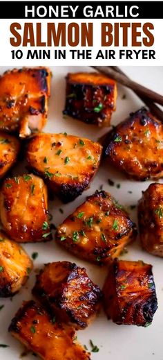 grilled honey garlic salmon bites on a white plate with chopsticks and parsley