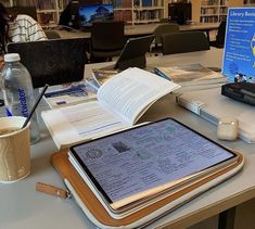 there is a tablet and some books on the table