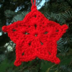 a red crocheted ornament hanging from a tree