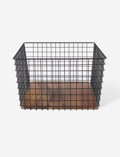 a black wire basket with wood flooring on the bottom and sides, against a white background