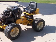 a yellow riding mower sitting on top of a sidewalk