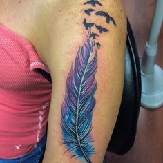 a woman with a tattoo on her arm has a blue feather and birds flying in the sky