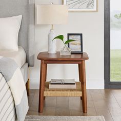 a bedroom with a bed, nightstand and pictures on the wall