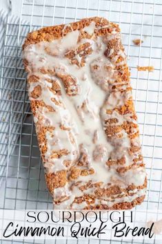 a loaf of cinnamon quick bread on a cooling rack with icing drizzled over it