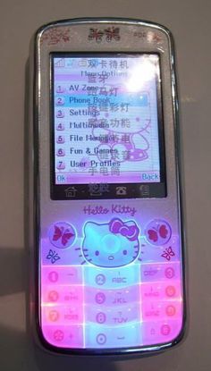 a hello kitty cell phone is lit up with pink and blue lights on the screen