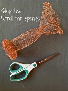 a pair of scissors sitting next to a piece of wire wrapped in copper foil with the words, step two unroll the sponge