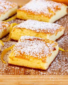 several pieces of cake sitting on top of a cutting board covered in powdered sugar