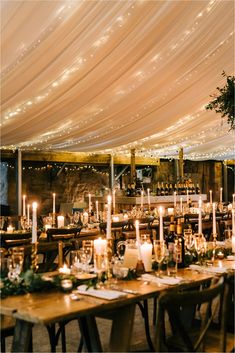 the tables are set up with candles and place settings for an elegant dinner or reception