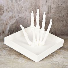 a white plastic skeleton hand sitting on top of a counter