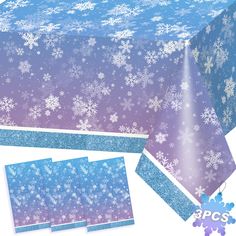 the table cloth has snowflakes on it and is blue with white glitters