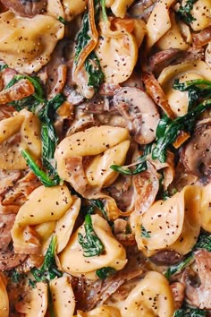 pasta with mushrooms and spinach in a skillet on a wooden table, ready to be eaten