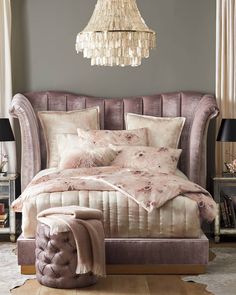 a bedroom with a bed, chair and chandelier