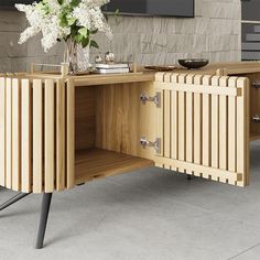 a vase with white flowers sitting on top of a wooden sideboard