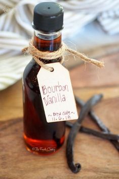 a bottle of bourbon vanilla sits on a table next to an old pair of scissors