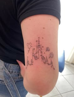 a woman with a tattoo on her arm that has a castle and fireworks in it