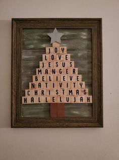 a wooden scrabble christmas tree with words written on it