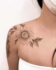 a woman with a sunflower tattoo on her upper arm and shoulder, wearing a white dress