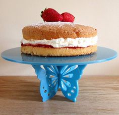 a cake sitting on top of a blue plate covered in frosting and strawberries