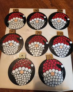 six christmas ornaments are sitting on top of a sheet of white paper with red, white and black circles