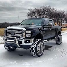 a black truck is parked on the side of the road in the snow and ice