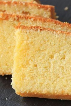 two slices of yellow cake sitting on top of a black table next to each other