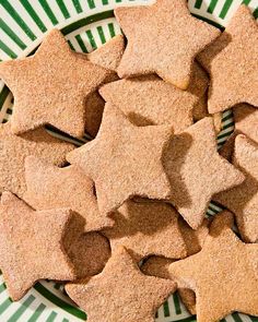 a plate full of star shaped cookies on top of a green and white striped tablecloth