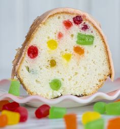 a slice of cake with gummy bears on it next to some candy candies