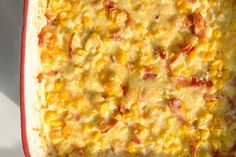 a casserole dish with corn and cheese on it, ready to be eaten