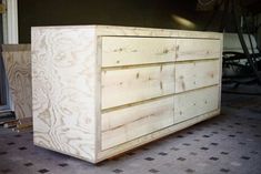 a wooden dresser sitting on top of a tiled floor