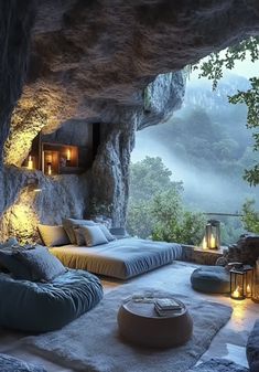 a cave like room with two beds and candles on the floor, surrounded by rocks