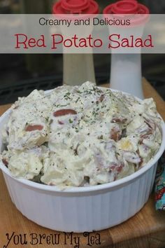 red potato salad in a white dish on a wooden cutting board with the title creamy and delicious red potato salad