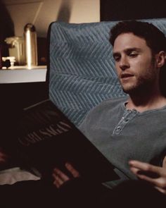 a man sitting in a chair reading a book