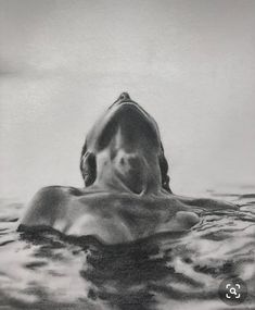 a black and white photo of a shark swimming in the ocean with its mouth open