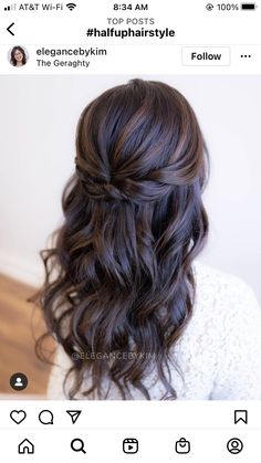 the back of a woman's head with long dark brown hair and wavy curls