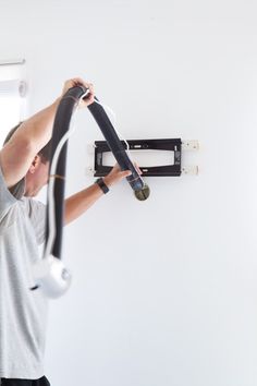 a man working on an electrical device in a room with white walls and flooring