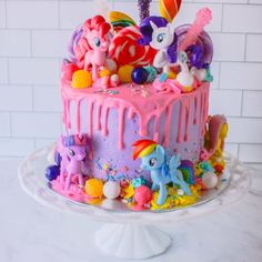 a birthday cake decorated with little pony toys