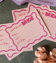 three pink paper cards with the word bride on them and some flowers next to it