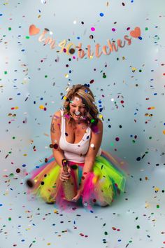 a woman sitting on the ground surrounded by confetti