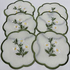 six embroidered coasters with daisies and leaves on white fabric, set of four