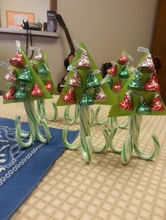 three green and red christmas trees sitting on top of a table