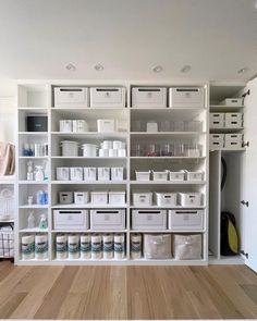 an organized pantry with white bins and drawers