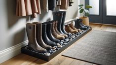 a row of boots sitting on top of a wooden floor next to a pile of rocks