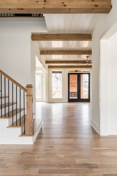 an empty living room with wood floors and white walls is seen from the entry way