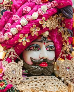 a close up of a statue of a person wearing a pink turban and headdress