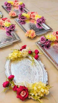 there are flowers on the table with mirrors in the backgrounnd and one is pink, yellow and red