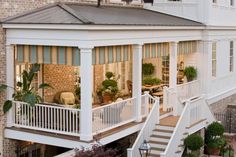 a white house with stairs leading up to the upper level and second story porch area